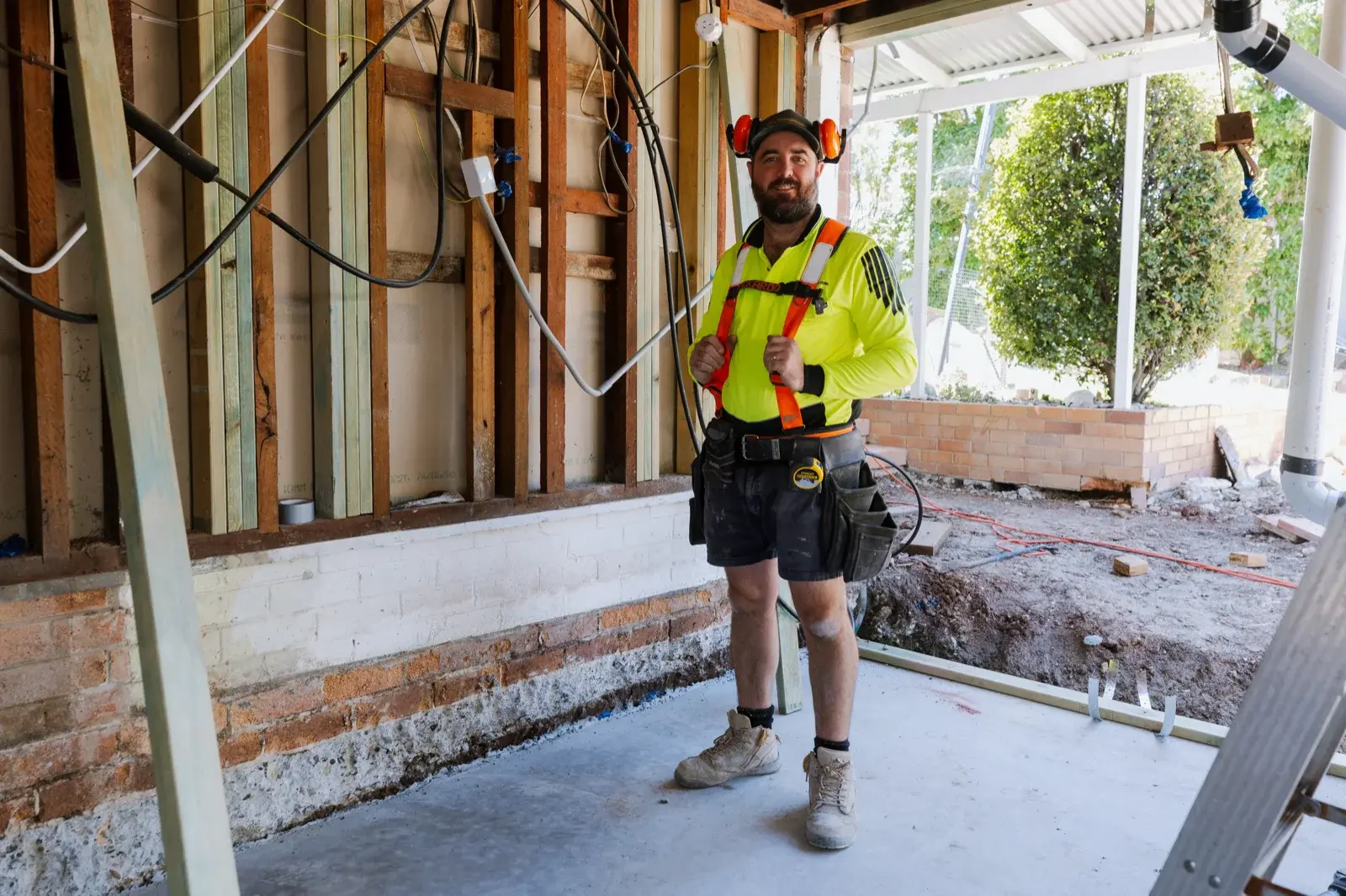 Farr Constructions builder standing inside a stripped renovation site in Brisbane — showing the complexity an owner-builder would need to manage alone
