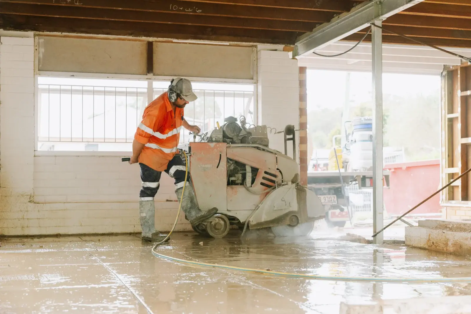 Farr Constructions tradesman operating a floor saw to cut internal concrete slab during a major home renovation in Brisbane