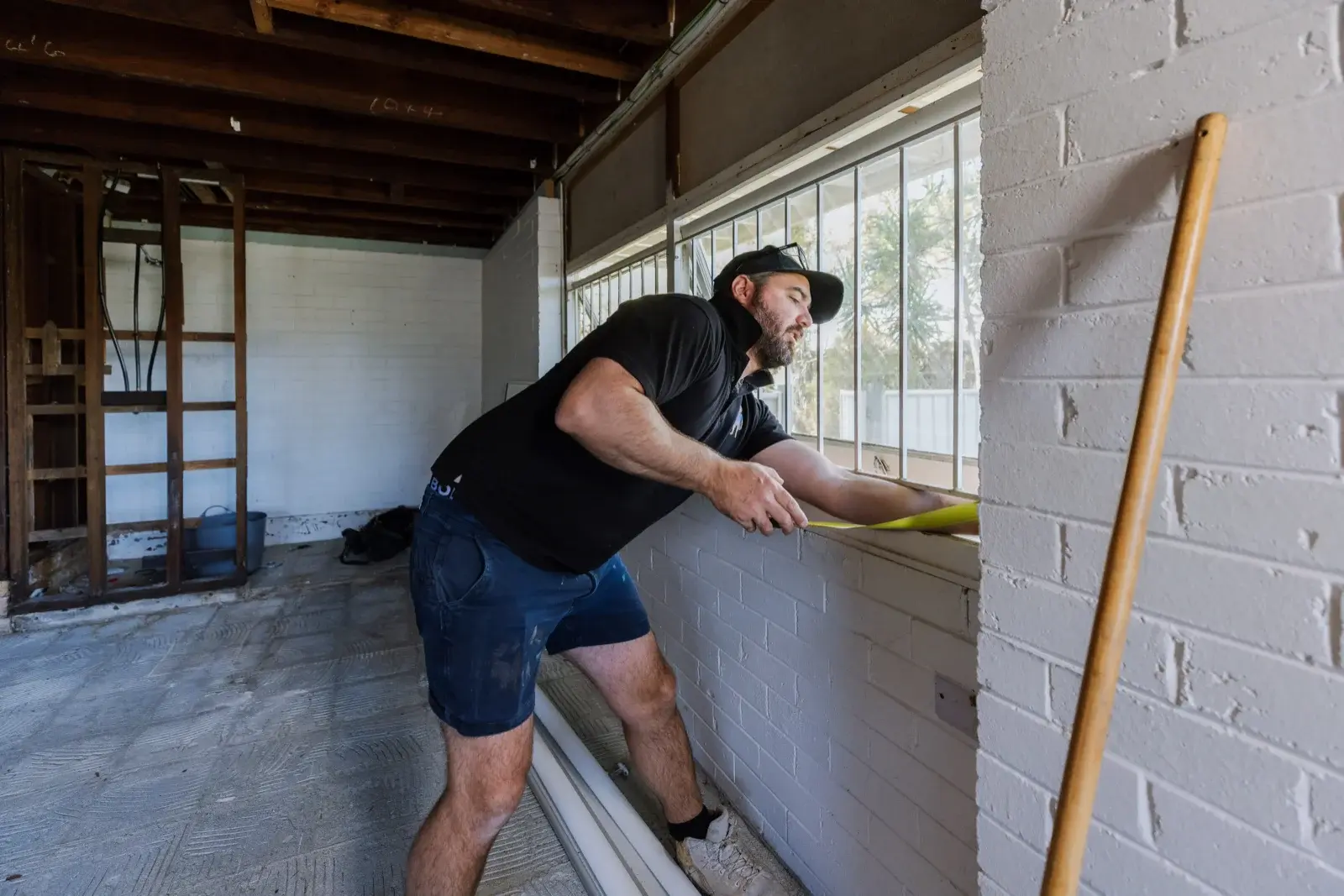 Farr Constructions builder inspecting lower level window during Tarragindi internal renovation in Brisbane