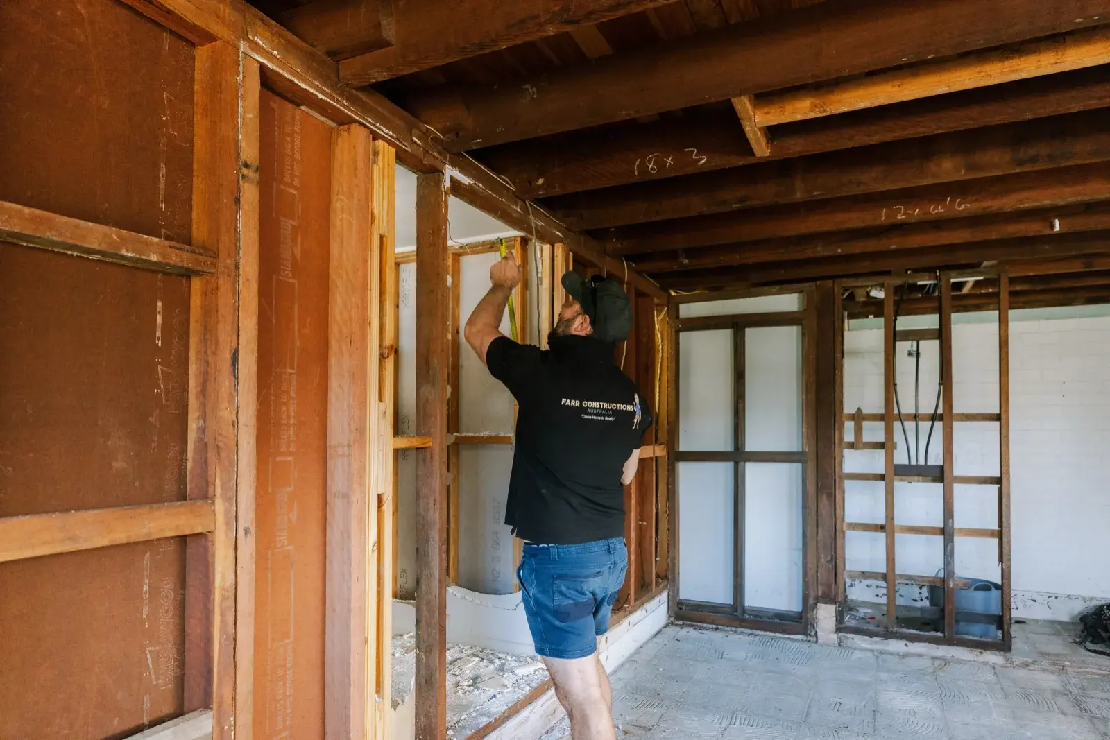 Farr Constructions carpenter measuring new timber framing on lower level of Tarragindi home renovation Brisbane