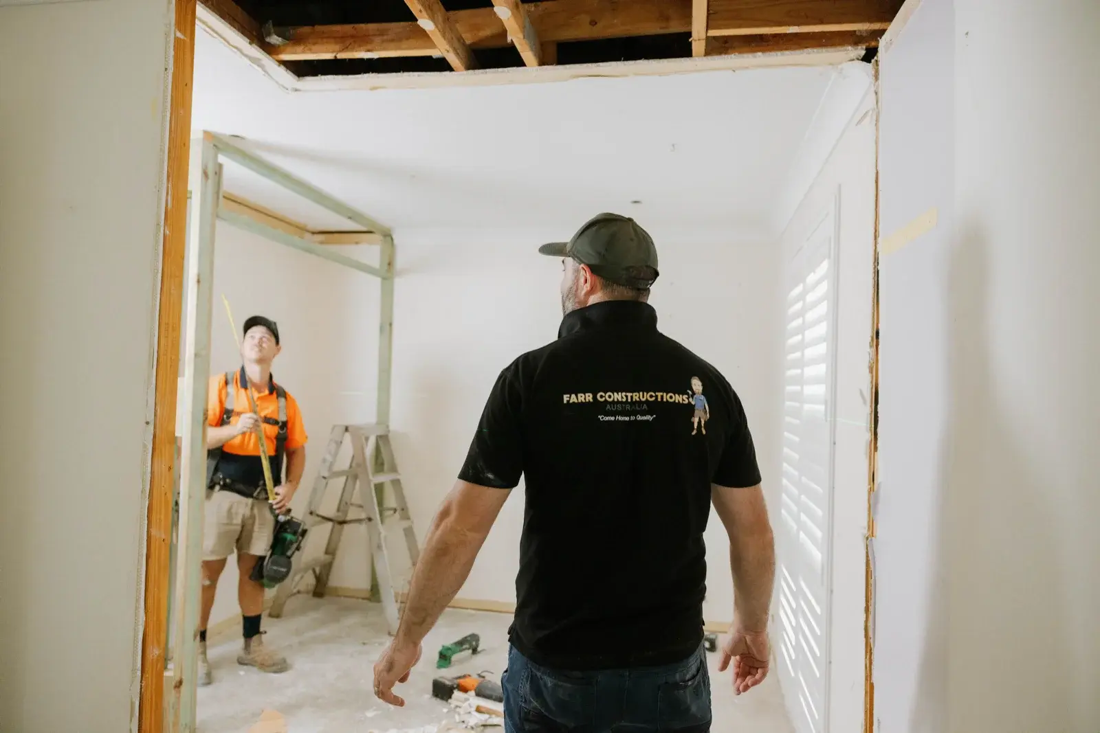Farr Constructions builder and tradesman inspecting new doorway framing on Taigum renovation site
