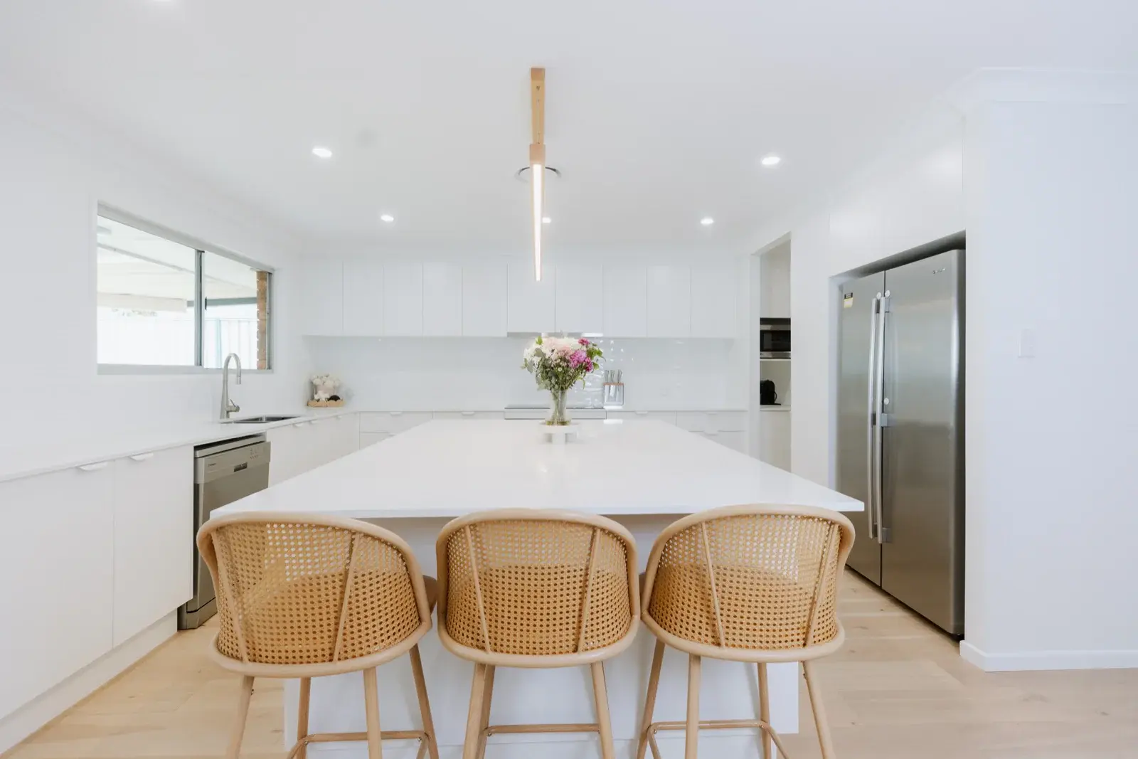 Kitchen renovation Rochedale South — new island bench with white cabinetry and rattan bar stools