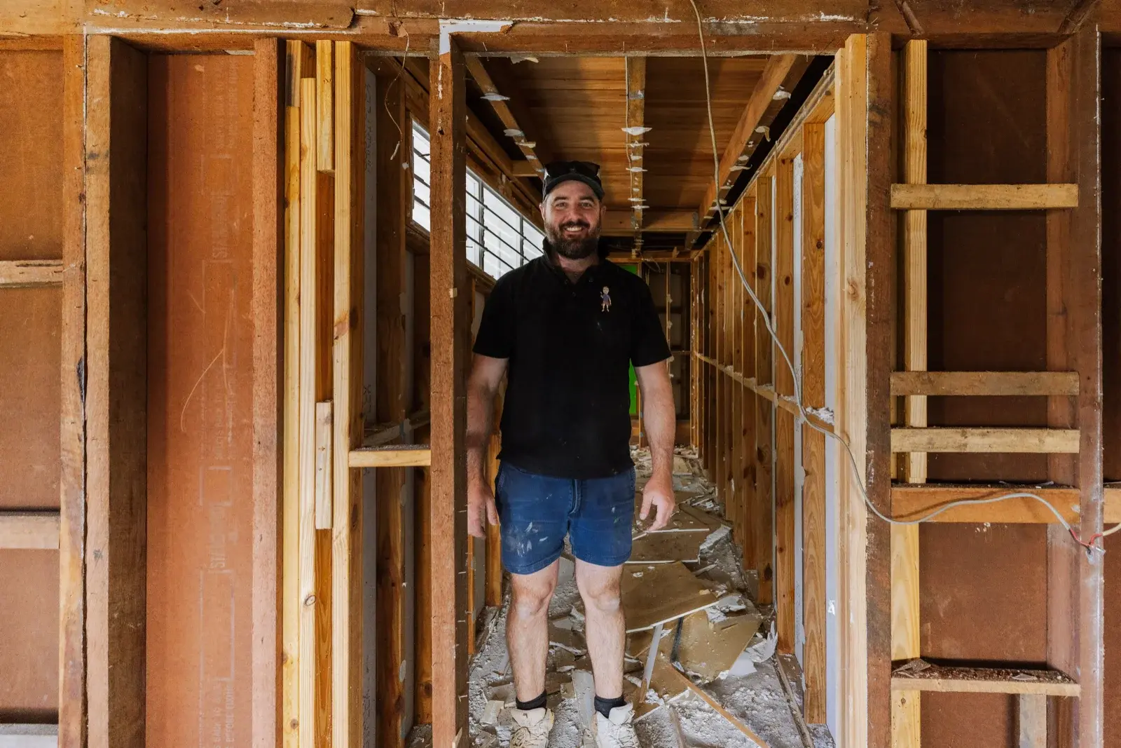 Tomas Farr inside newly framed lower level at Tarragindi internal renovation — structural framing complete, ready for fitout